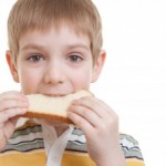 Boy eating slice of bread